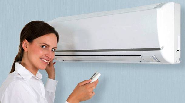 satisfied homeowner turning on the ac with remote control